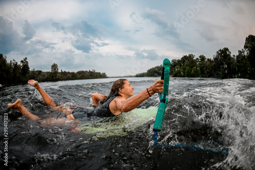 Girl wakesurfer falling off a surf board