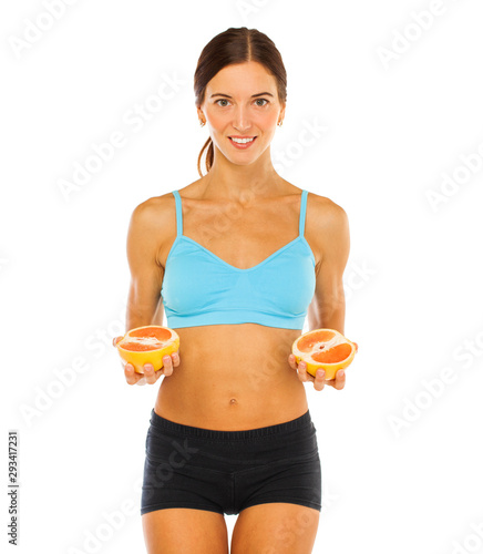 Young athletic girl holding two doldts of grapefruit © Andrey_Arkusha