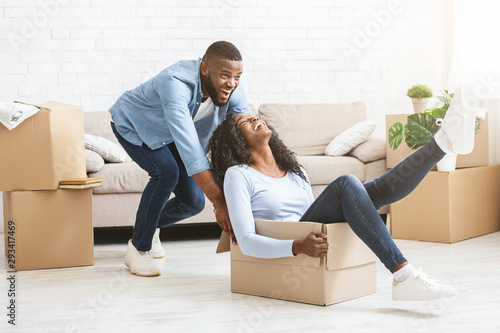 Playful man pushing box with his woman, moving in © Prostock-studio