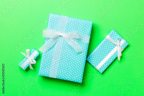 Top view Christmas present box with white bow on green background