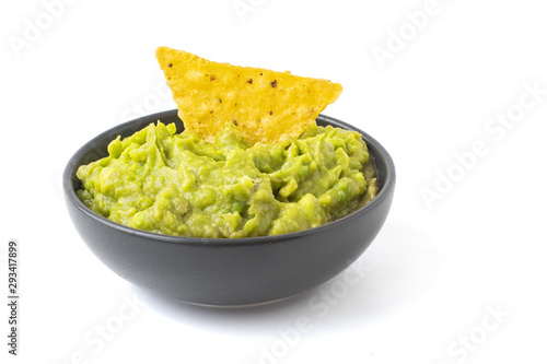 Green Guacamole with nachos in dark bowl isolated on white background
