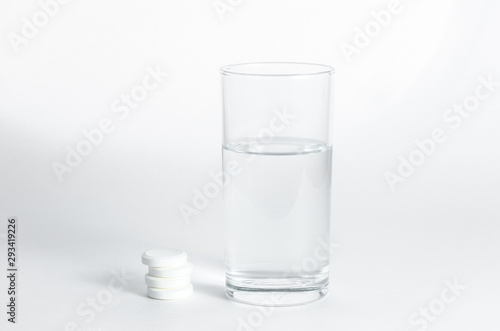 Transparent glass of water and soluble effervescent tablets isolated on white background. The concept of treatment and prevention of viral diseases. Help with depression and insomnia.Drinking medicine