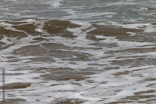 Fale rozbijające się o piaszczysty brzeg © Miroslaw