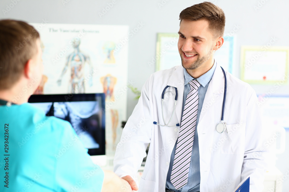Portrait of joyful specialist greeting colleague with gladness. Intelligent doctor wearing white robe blue shirt and striped tie. Medical treatment concept. Blurred background Portrait of joyful specialist greeting colleague with gladness. Intelligent doctor wearing white robe blue shirt and striped tie. Medical treatment concept. Blurred background