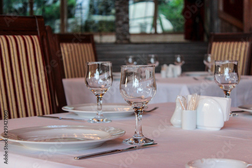 Close-up of wine glasses and plates placed on the table in the restaurant