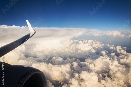 Piece of engine and wings during flight with beautiful cloudy sky in background, copy space, travel and digital nomad concept