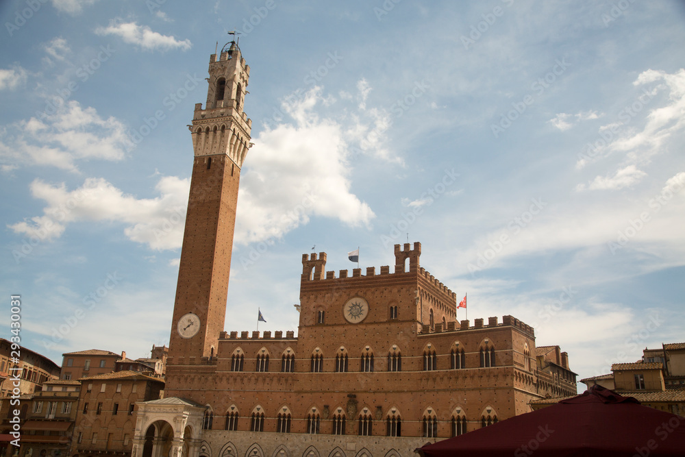 Siena townhall under blue sky, with tower of Mangia