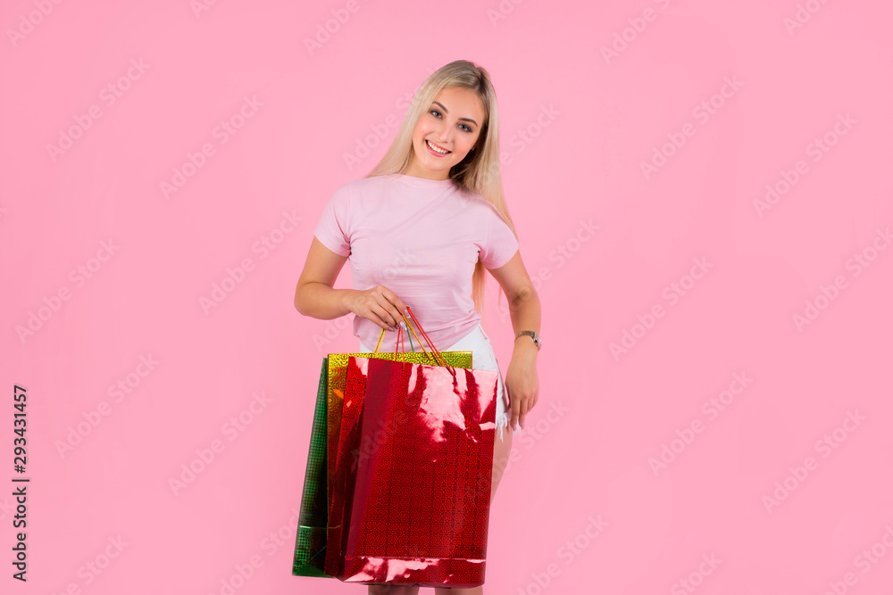 beautiful young woman on a pink background with packages in hands beautiful young woman on a pink background with packages in hands