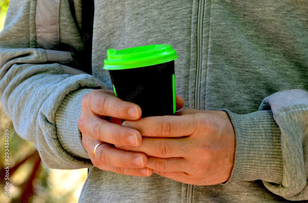 Man holds coffee cup,autumn photo Man holds coffee cup,autumn photo