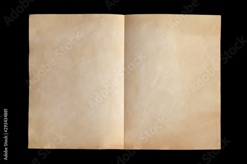 Weathered crumpled vintage sheet of paper folded in half isolated on black background. Closeup. Top view. Copy space