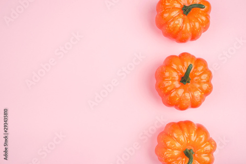 Pink background with three pumpkins.