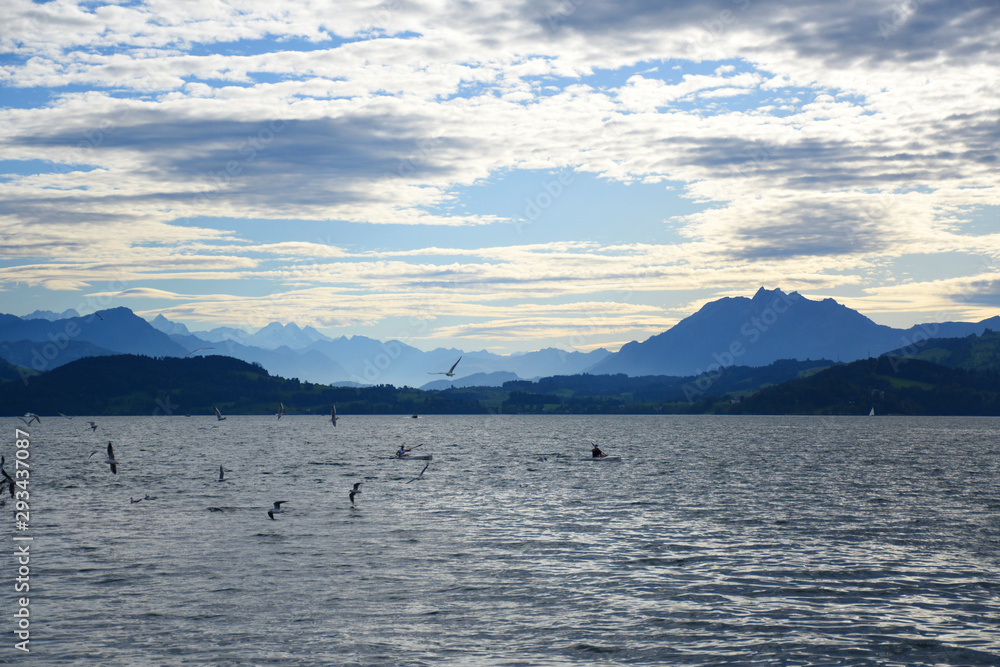 Landscape view of Lake Zug with cirrus clouds and mountains in the distance Landscape view of Lake Zug with cirrus clouds and mountains in the distance