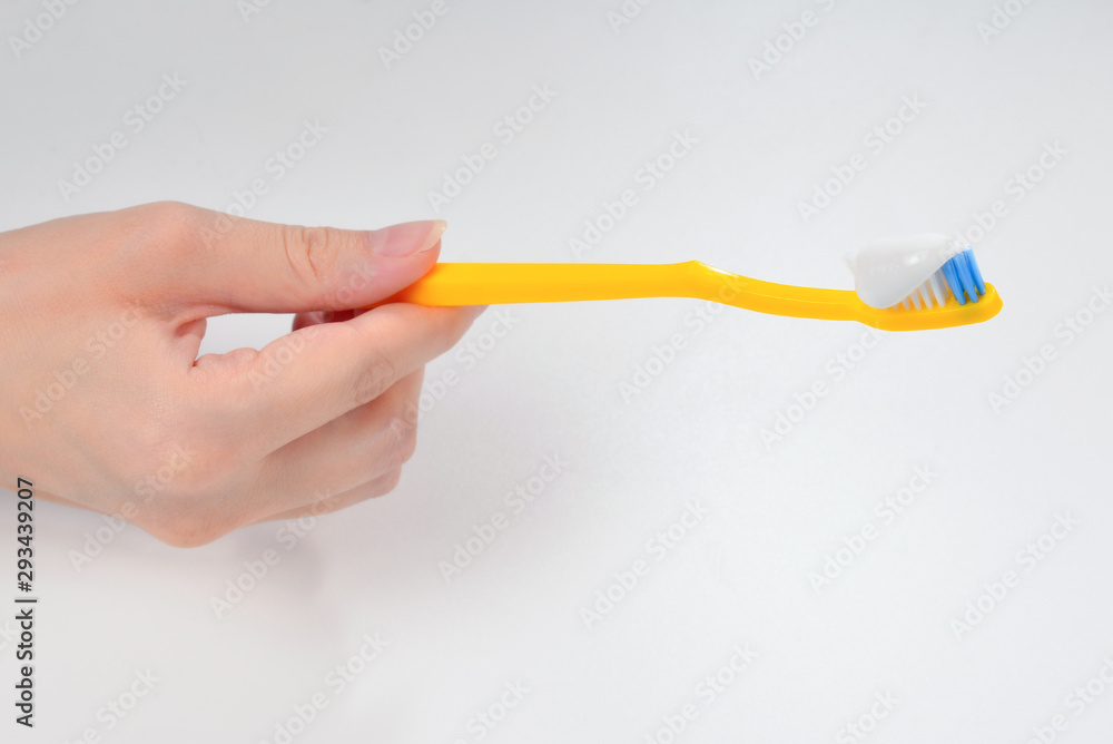 Woman holds toothbrush with toothpaste in her hand isolated on white background. Woman holds toothbrush with toothpaste in her hand isolated on white background.