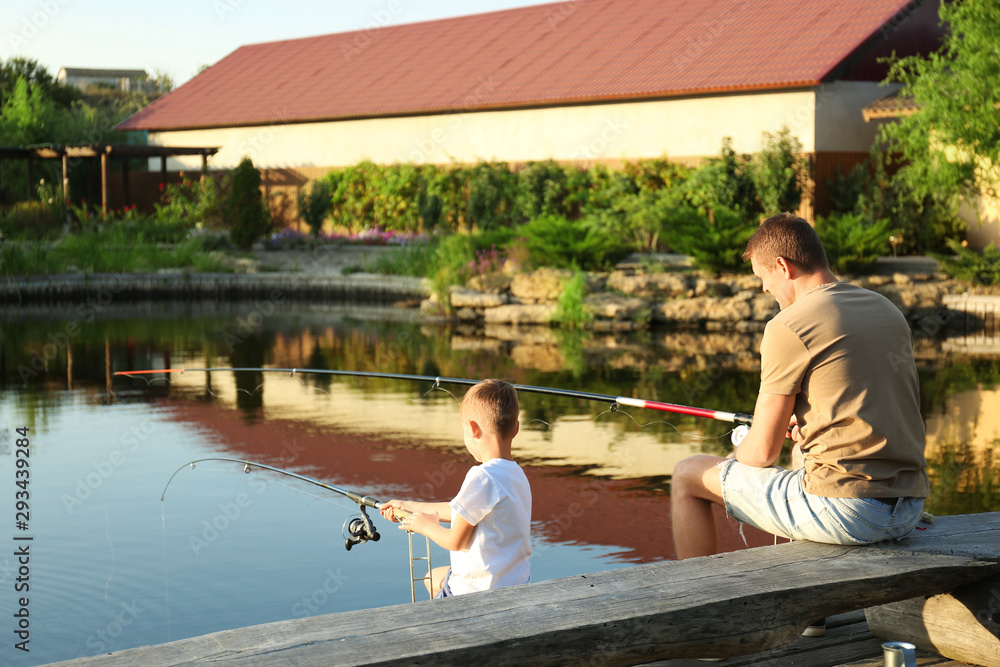 Dad and son fishing together on sunny day Dad and son fishing together on sunny day
