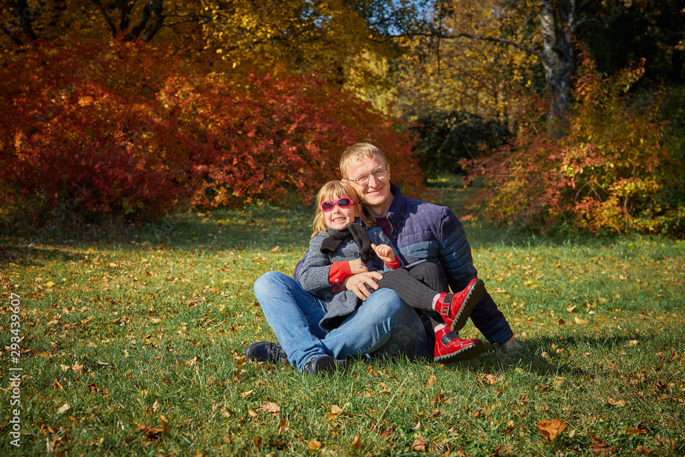 Dad plays with his daughter in park.
