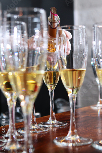 A large number of glasses with white wine at the bar. Wine tasting concept in a restaurant. Out of focus. Photo in the interior.