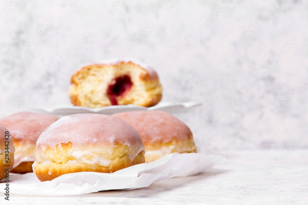 Traditional Polish donuts with frostng on light background. Tasty doughnuts with jam.