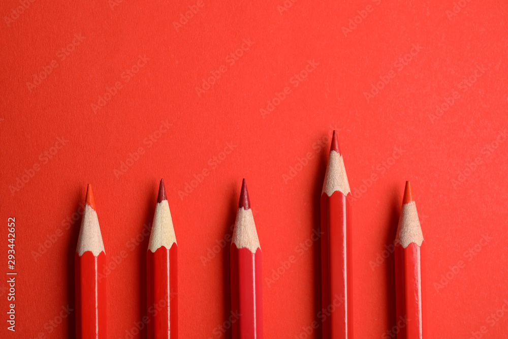 Flat lay composition with color pencils on red background Flat lay composition with color pencils on red background