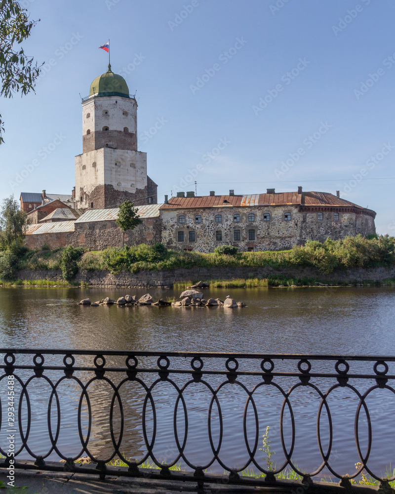 View of ancient Vyborg castle with embankment fence in summer. Russia..