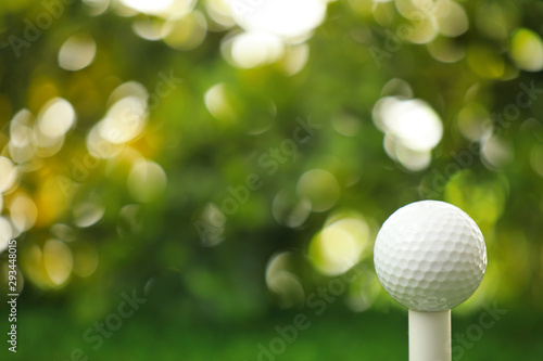 Golf ball on tee against blurred background