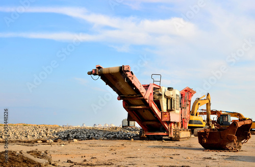 Mobile Stone crusher machine by the construction site or mining quarry for crushing old concrete slabs into gravel and subsequent cement production photo