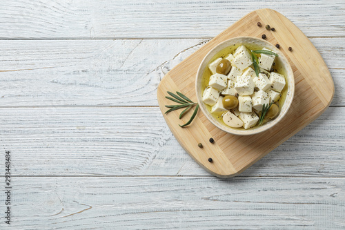 Photos Flat lay composition with pickled feta cheese in bowl on white wooden table, spa