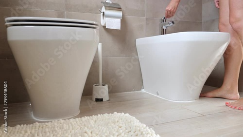 Intimate zone washing concept. Woman taking hygiene shower with bidet at bathroom photo