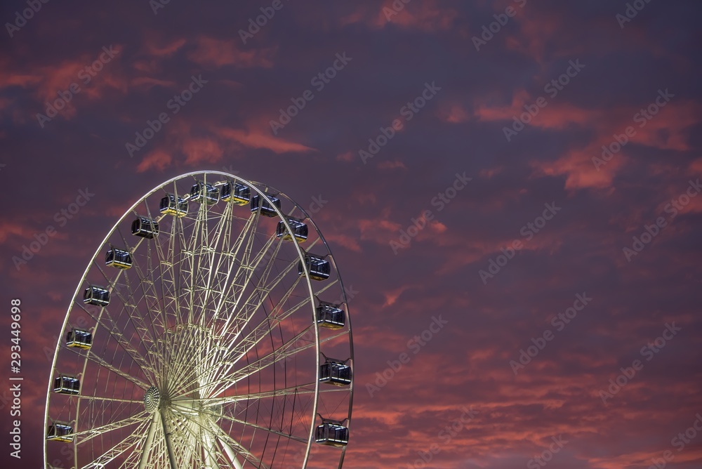 Illuminated Ferris wheel with beautiful colorful sky in the magic hour