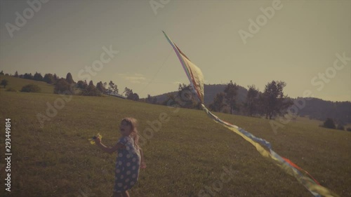 Nostalgia look of a little girl flying a colorful kite photo