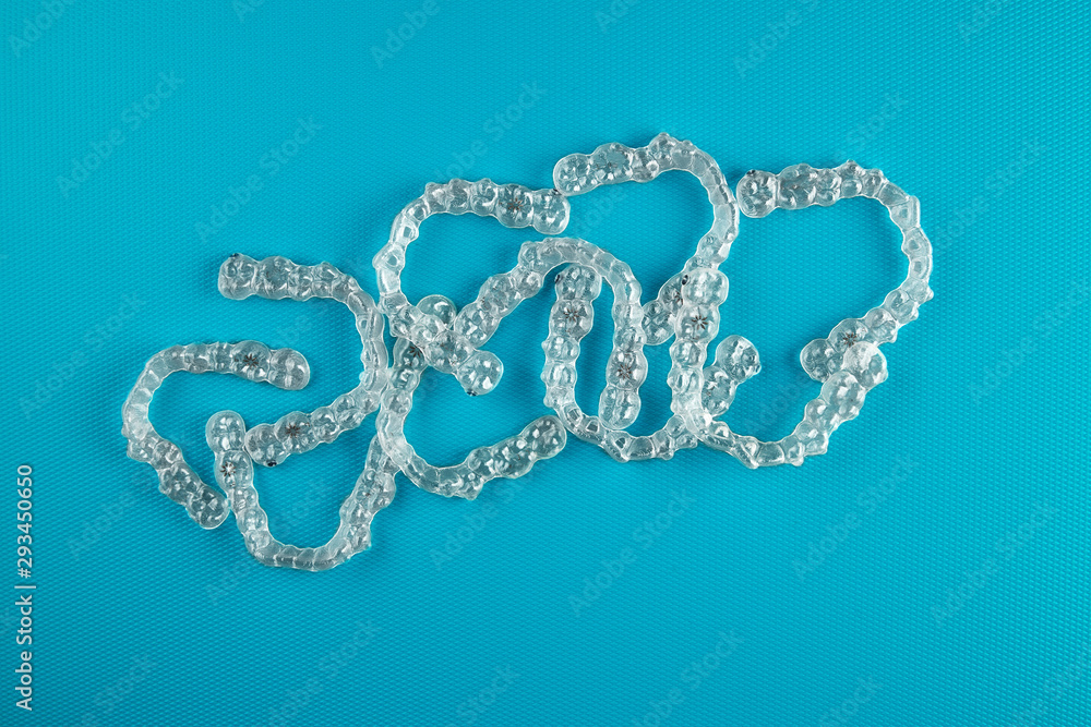 Top view of invisalign braces or invisible retainers on blue background, new orthodontic equipment