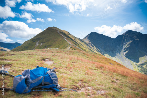 Blue Rucksack and mountain path in the background - trekking equipment, hillwalking gear, mountaineering