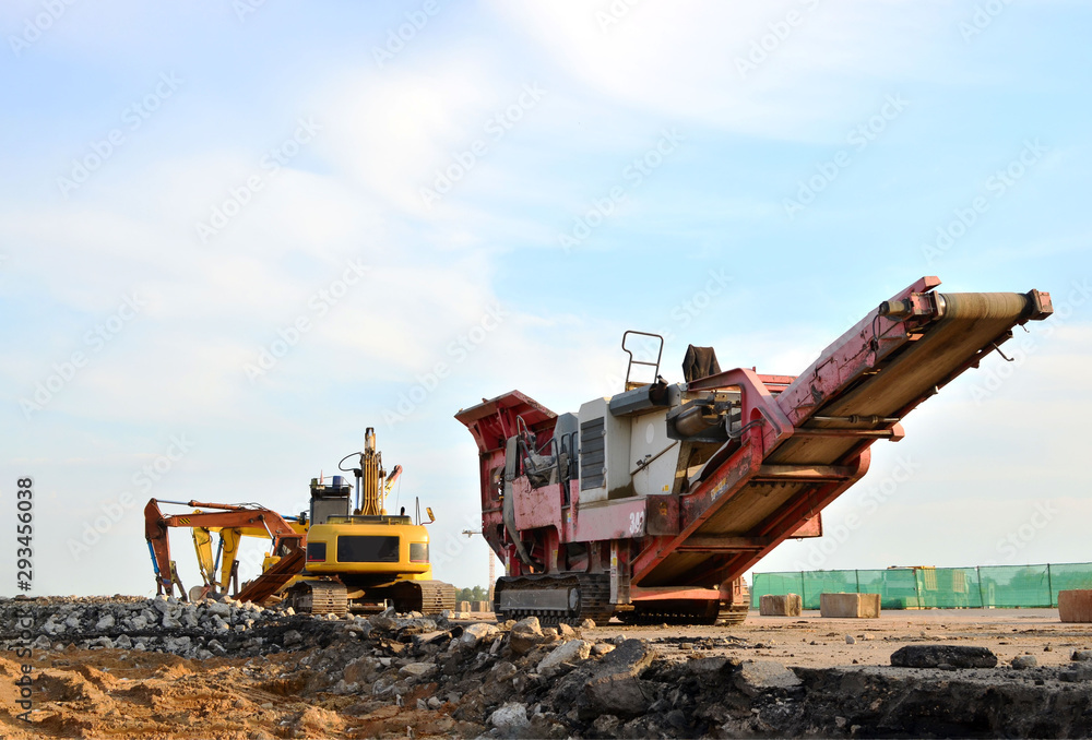 Mobile Stone crusher machine by the construction site or mining quarry for crushing old concrete slabs into gravel and subsequent cement production Mobile Stone crusher machine by the construction site or mining quarry for crushing old concrete slabs into gravel and subsequent cement production
