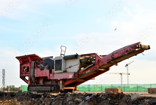 Mobile Stone crusher machine by the construction site or mining quarry for crushing old concrete slabs into gravel and subsequent cement production
