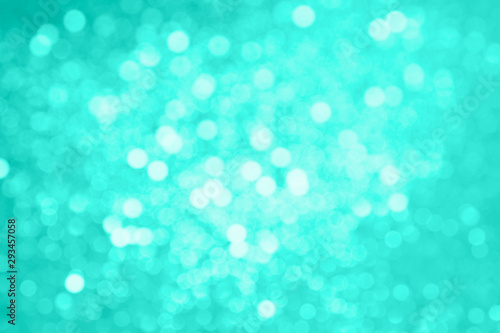 Abstract composition. Blurred photo of glitter with beautiful bokeh in turquoise. Defocused light.