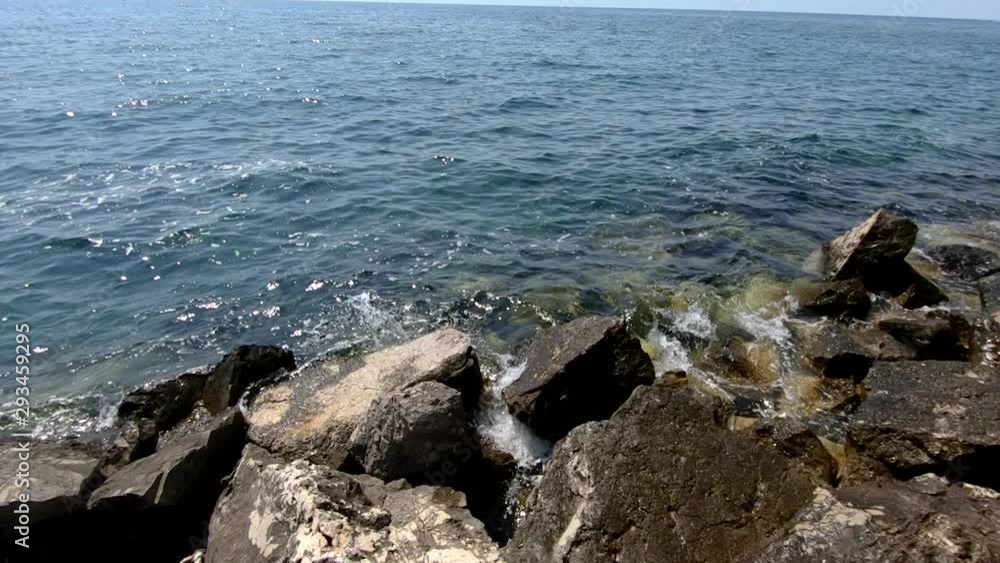 Slow motion left pan sharp rock water waves barrier protection Slow motion left pan sharp rock water waves barrier protection