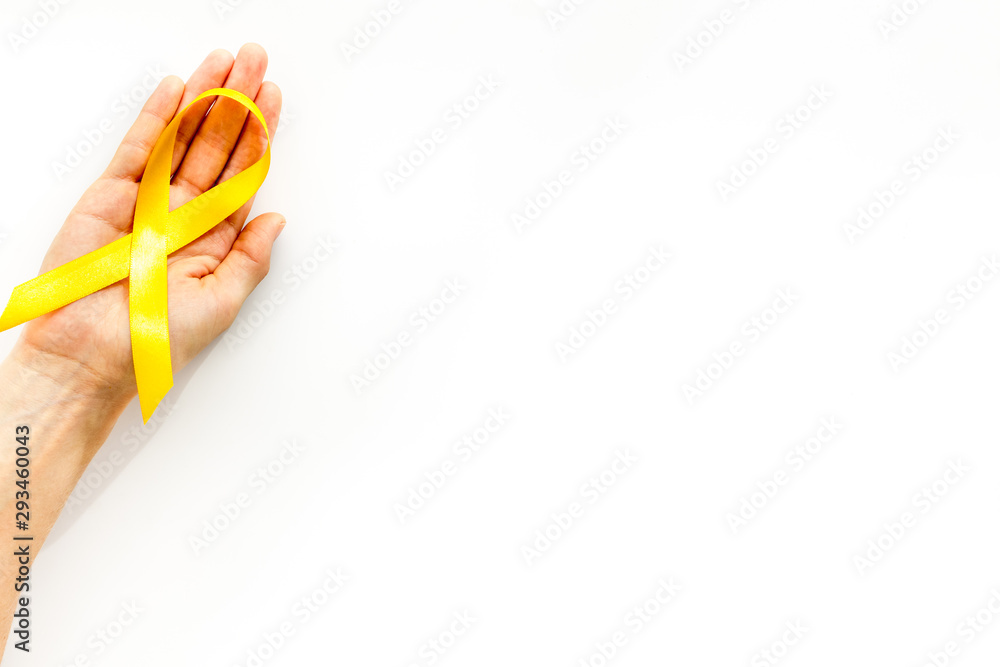Disease control concept. Orange ribbon in hands on white background top view copy space Disease control concept. Orange ribbon in hands on white background top view copy space