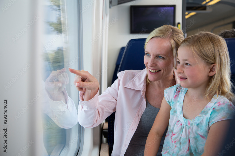 Mother and daughter traveling by train, pointing out of window Mother and daughter traveling by train, pointing out of window