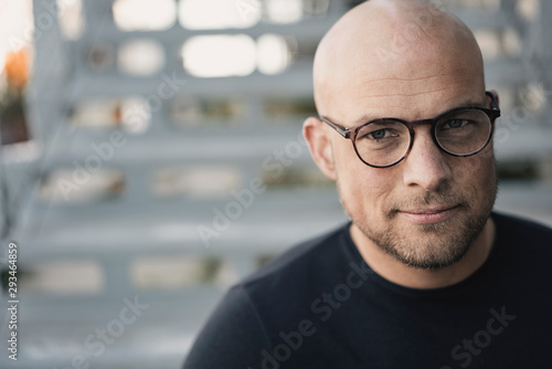 Portrait of bald man with beard wearing glasses photo