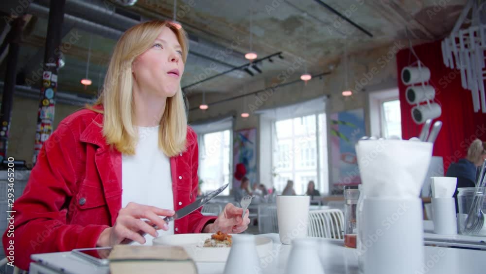 Beautiful hipster girl eats in cafe and use phone, she likes food Beautiful hipster girl eats in cafe and use phone, she likes food