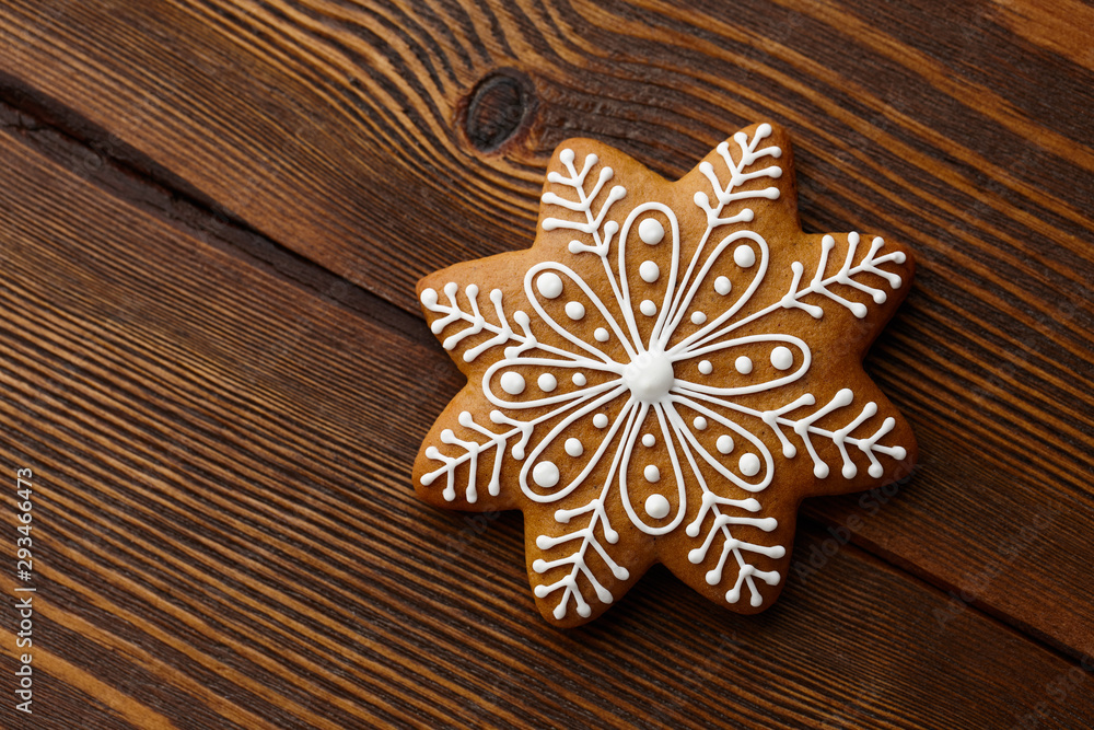 Christmas gingerbread snowflake on wooden texture Christmas gingerbread snowflake on wooden texture