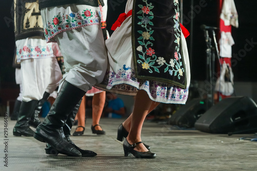 Close up of legs of young Romanian female and male dancers in traditional folkloric costume. Folklore of Romania