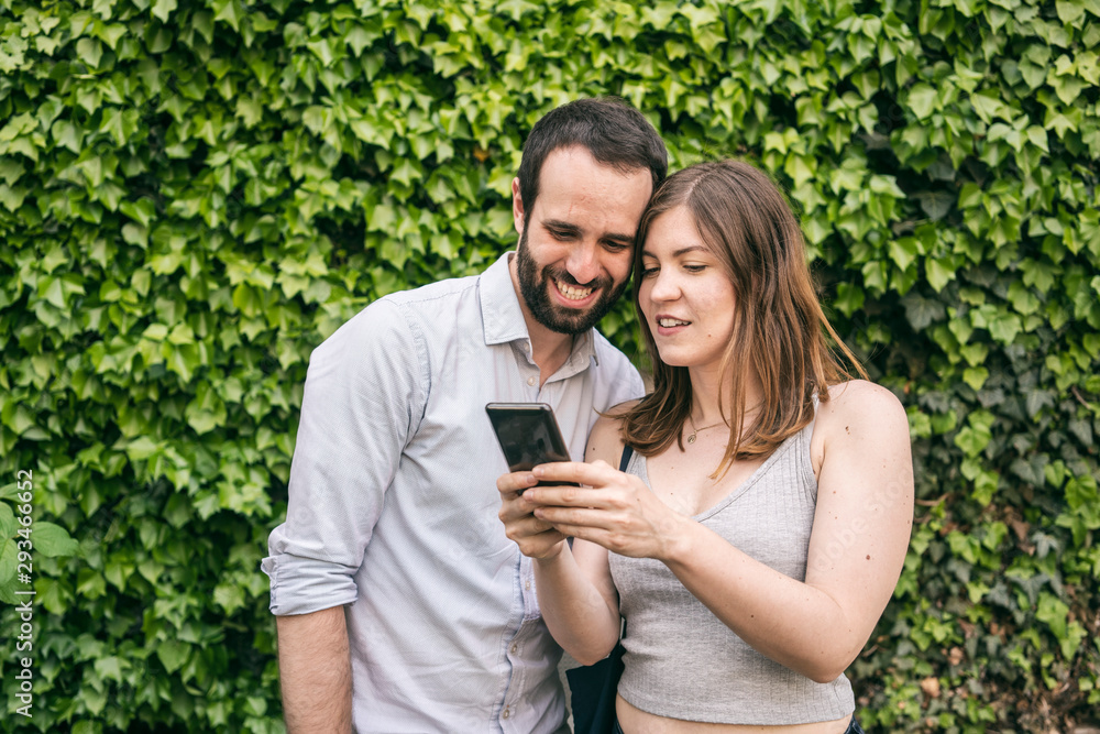 Happy young couple sharing cell phone Happy young couple sharing cell phone