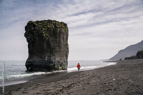 Woman on lava beach in South East Iceland, walk at the sea photo