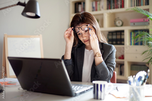 young business woman rubbing eye in the office