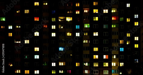 Night panorama time lapse of light in windows of multistory buildings. life in big city