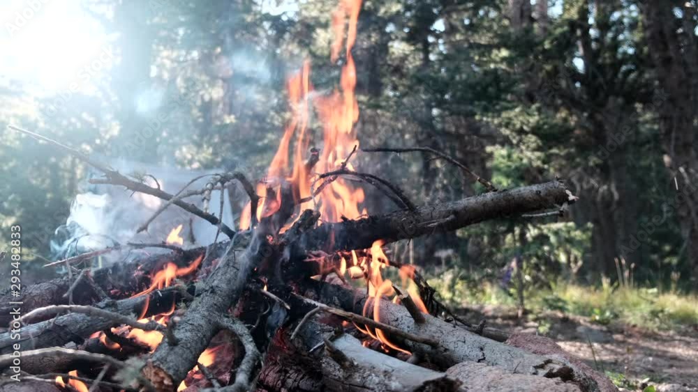 Campfire in sunrise, empty camp chair in background. Static slomo Campfire in sunrise, empty camp chair in background. Static slomo
