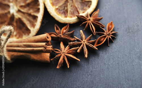 Christmas spices background. Cinnamon, dried oranges and anise on stone background.