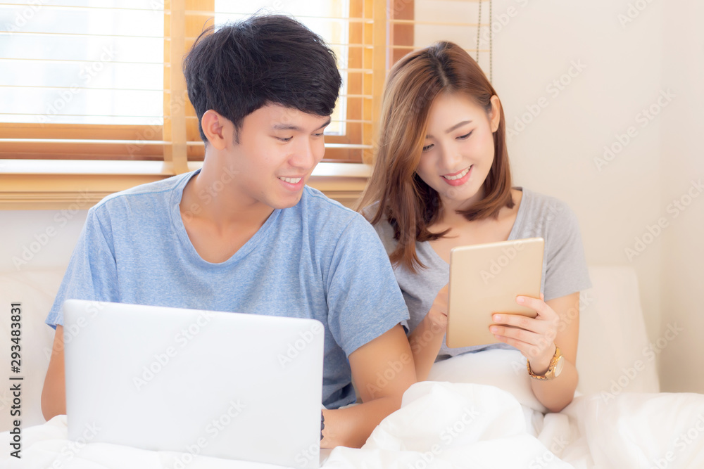 Beautiful young asian couple cheerful freelance working with man using laptop and woman using tablet on couch, family relax and sharing communication together at home, lifestyle concept. Beautiful young asian couple cheerful freelance working with man using laptop and woman using tablet on couch, family relax and sharing communication together at home, lifestyle concept.