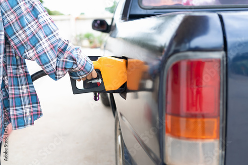 Commercial petroleum filling;woman service transfer gas from gas station to the black car .