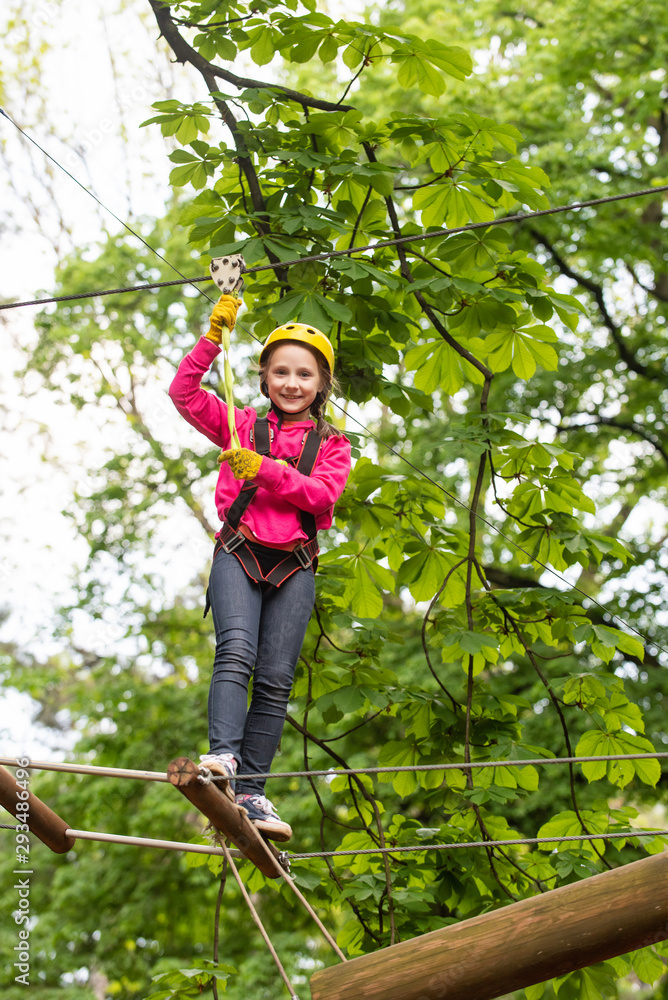 Adventure climbing high wire park. Child climbing on high rope park.  Beautiful little child climbing and having fun in adventure Park. Rope park.  Kids boy adventure and travel. Stock Photo